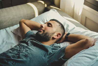Man resting in bed, winding down for the night