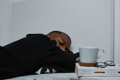 Man asleep next to a stack of books — nighttime wellness routine