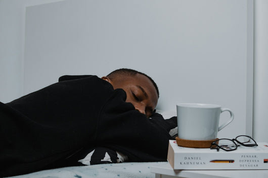 Man asleep next to a stack of books — nighttime wellness routine